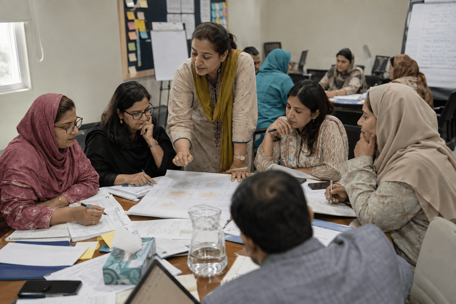 A trainer leading a cohort of teachers through a planning matrix during a capacity-building workshop.